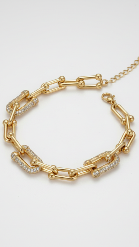 A bold 18K gold-plated U-link statement bracelet featuring three links covered in sparkling pave crystals.