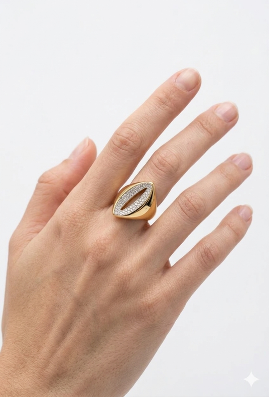 A bold 18K gold-plated marquis statement ring with a pavé crystal center cutout on a model's middle finger.