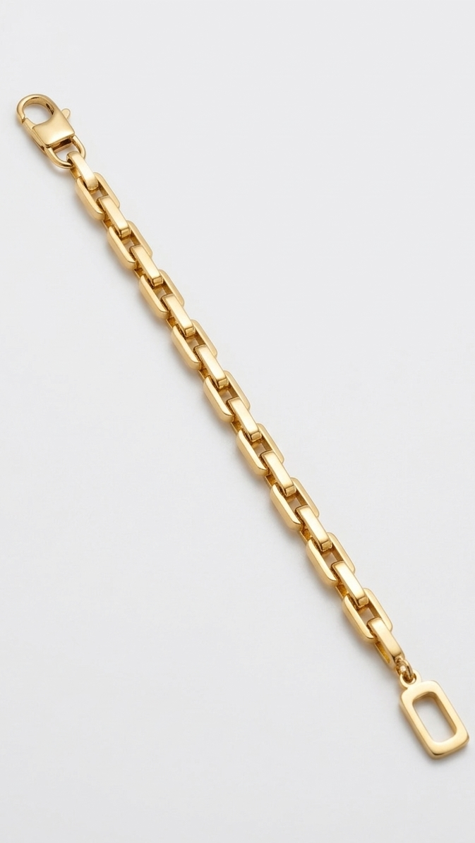 A bold 18K gold-plated rectangular box link bracelet featuring a single open-rectangle charm on a model's wrist.
