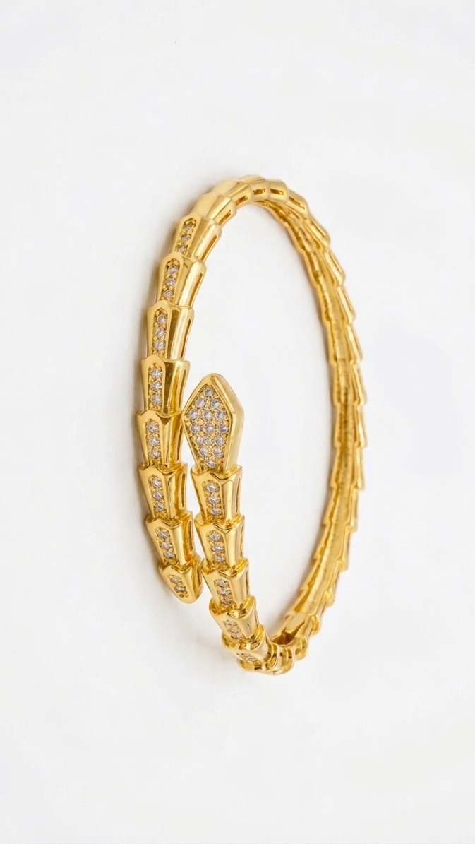 A bold 18K gold-plated serpent wrap-around bangle with shimmering pave crystals on the head and tail.
