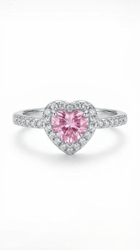 A chunky silver-plated signet ring featuring a large recessed pink heart-shaped crystal on a white background.