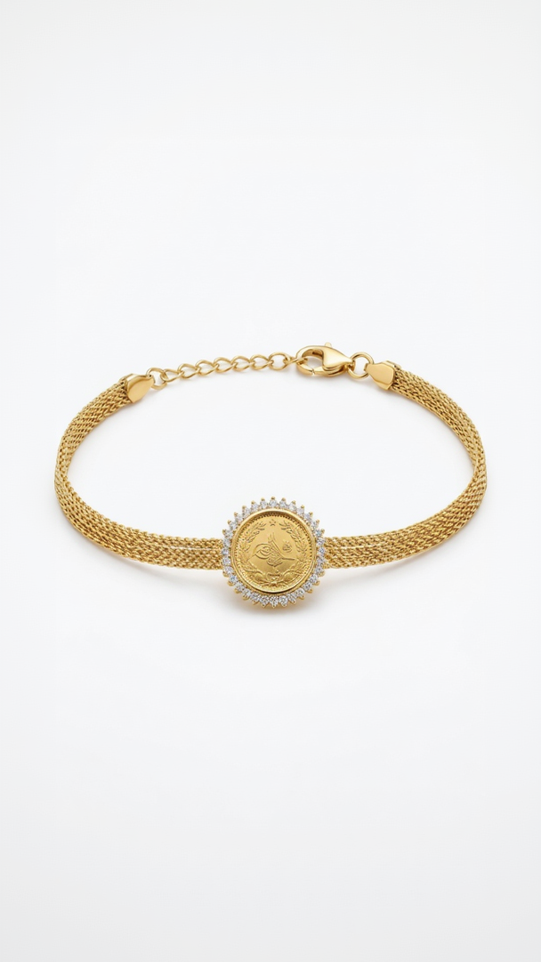 A detailed 18K gold-plated Ottoman coin medallion bracelet with a crystal halo and gold mesh strap on a model's wrist.