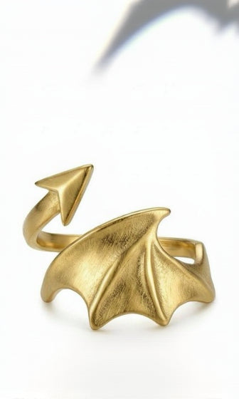 A detailed 18K gold-plated wrap ring featuring a textured dragon wing and an arrow-tipped tail in a bypass style.