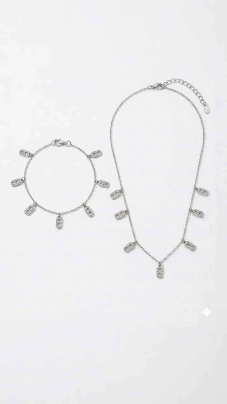 A matching silver-toned fine chain necklace and bracelet set featuring dangling rectangular charms with crystal pavé link details.
