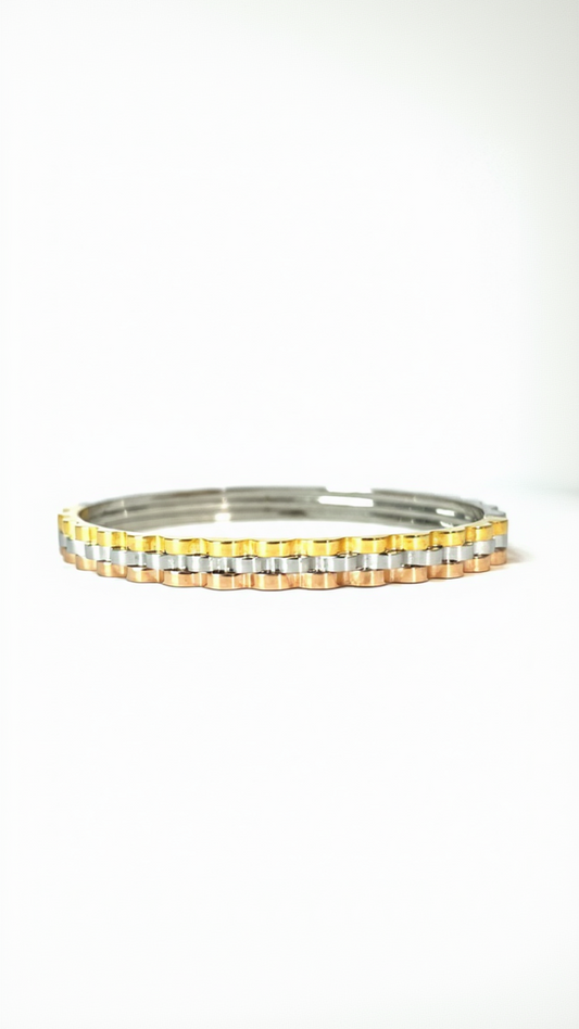 A structured tri-tone bangle featuring fused scalloped bands in yellow gold, rose gold, and silver with a high-polish finish.