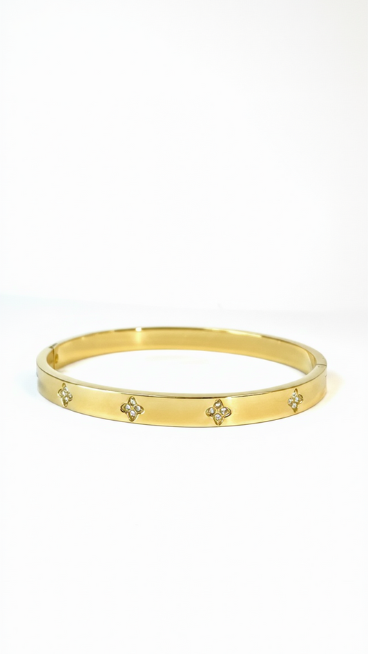 A thick 18K gold-plated bangle featuring a stack of three hollow rectangular geometric frames with a polished finish on a white background.