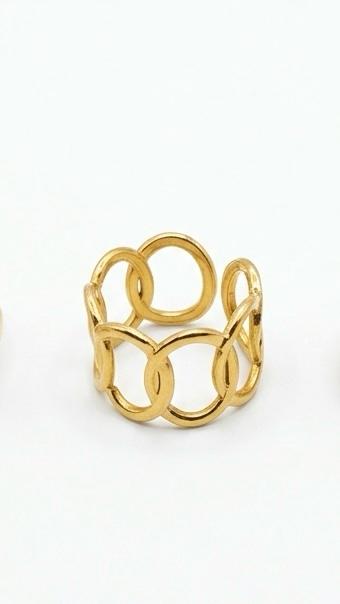 A wide 18K gold-plated ring featuring an interlocking open-circle chain design, shown on a model's finger.