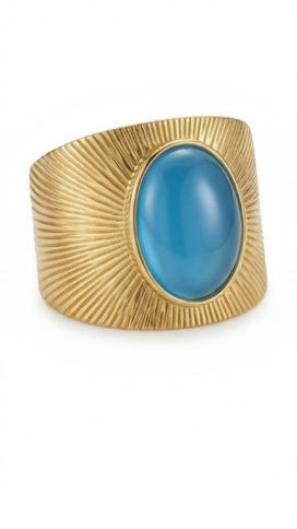 A wide 18K gold-plated signet ring featuring a large oval deep-blue stone and a radial sunburst engraved pattern.