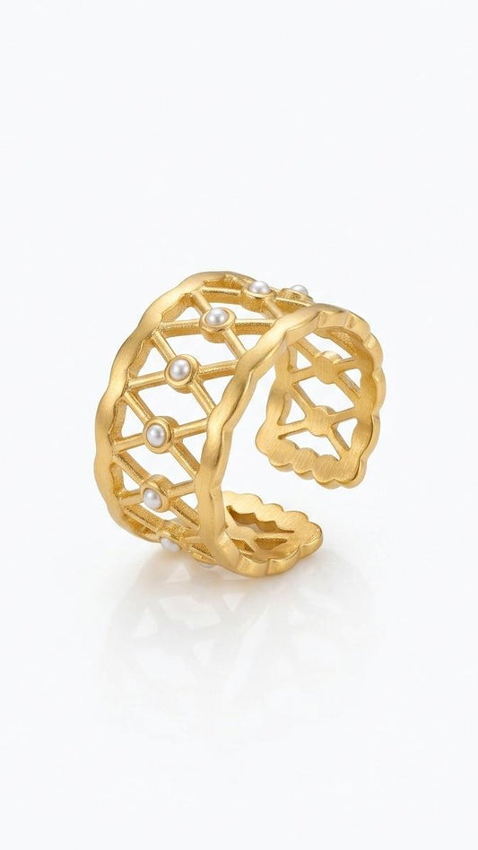 A wide matte 18K gold-plated lattice ring with small white pearls and a scalloped edge, shown on a model's hand and against a white background.