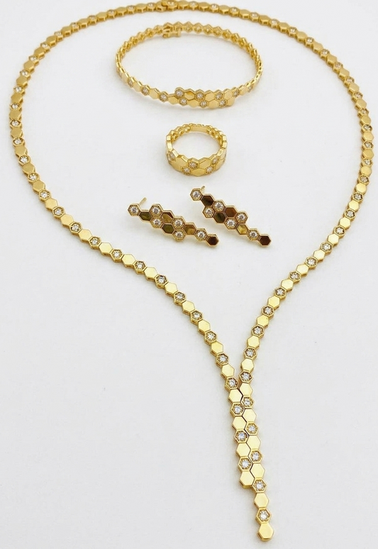 Gold necklace with matching bracelet, ring, and earrings on a white background
