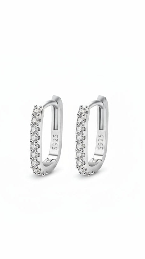 Pair of silver hoop earrings with clear stones on a white background