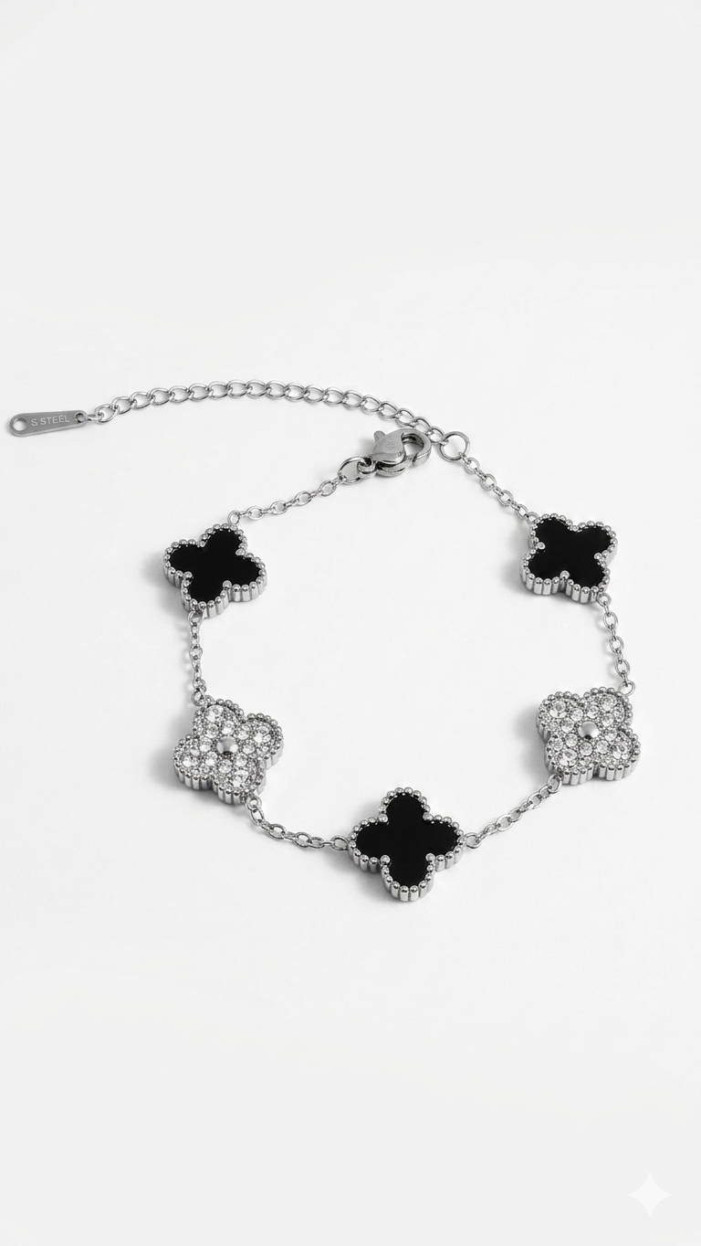 Silver bracelet with black clover-shaped charms on a white background