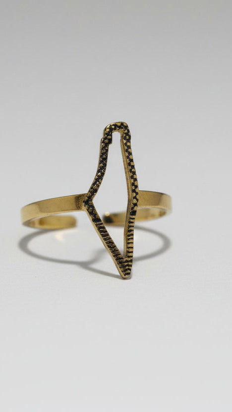 Gold ring with geometric design on a light gray background